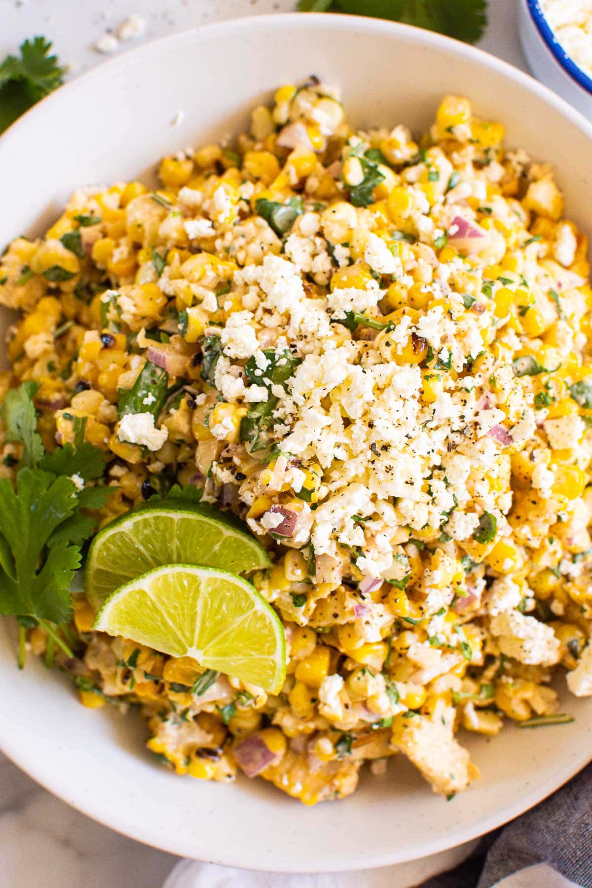 Mexican street corn salad with red onion, feta, lime and cilantro.