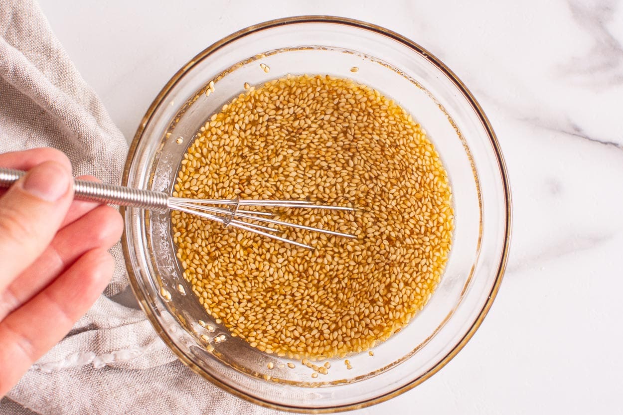 Salad dressing being whisked in a bowl.