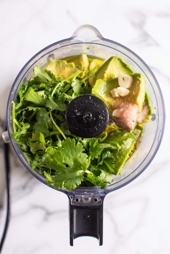 Fresh cilantro, avocado, oil, lime juice, garlic, salt and pepper in a food processor.