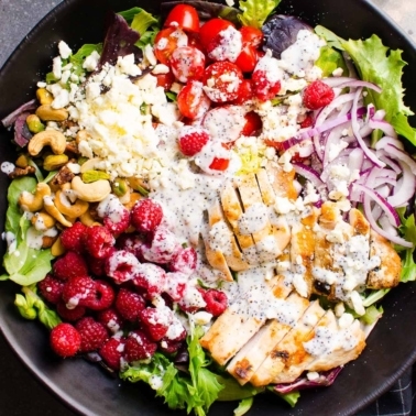 Grilled chicken salad in a bowl with healthy poppy seed dressing.