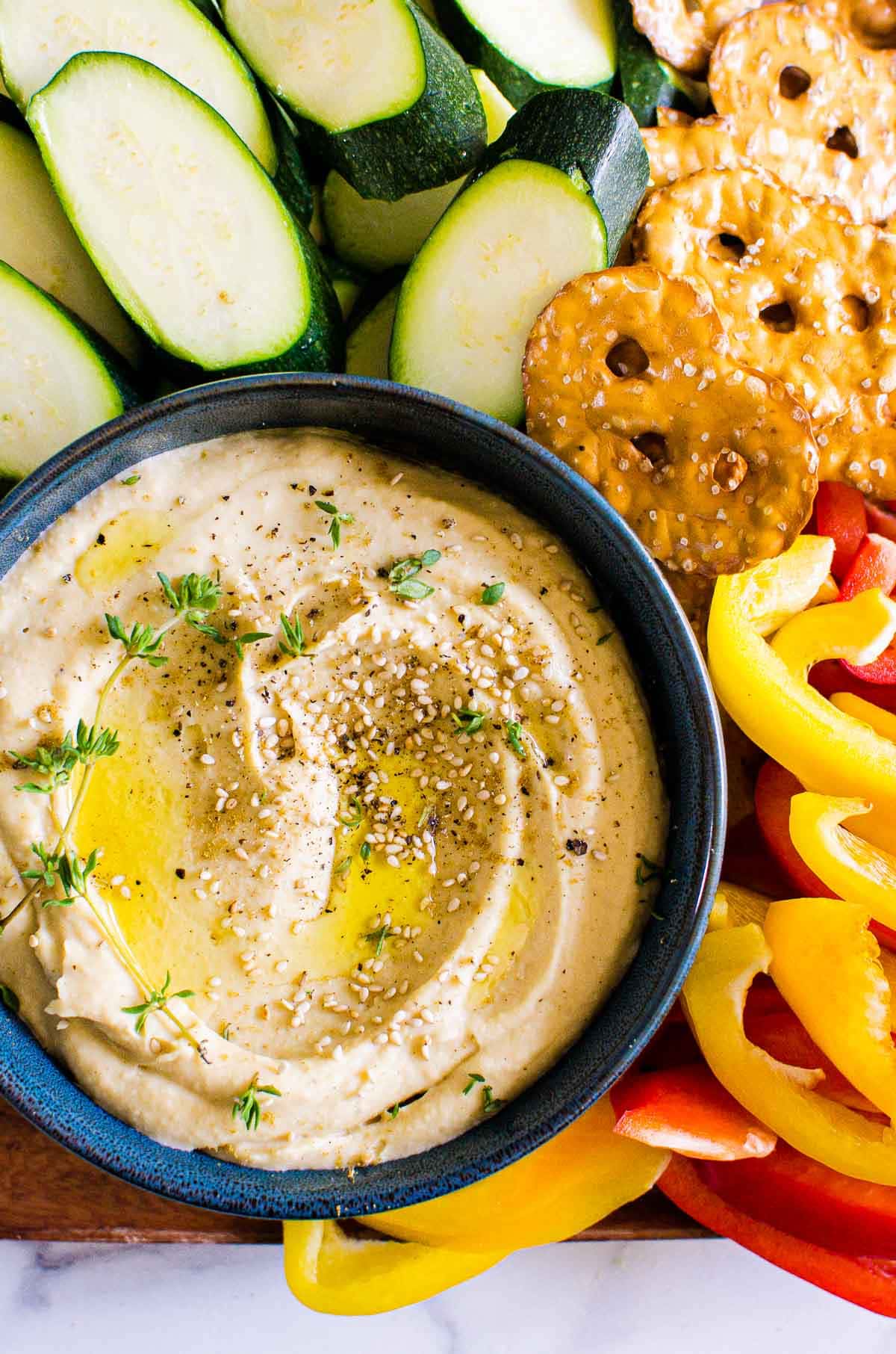 garlic hummus with fresh peppers pretzels and cucumber