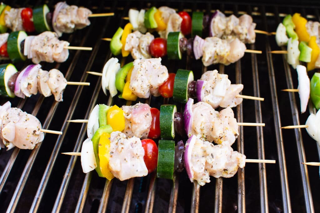 Chicken and vegetables on skewers on grill.
