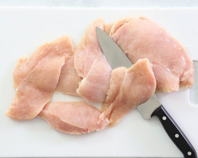 Raw chicken breasts with knife sliced thin.