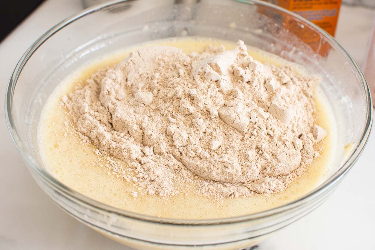 Whole wheat flour in bowl with wet batter. 