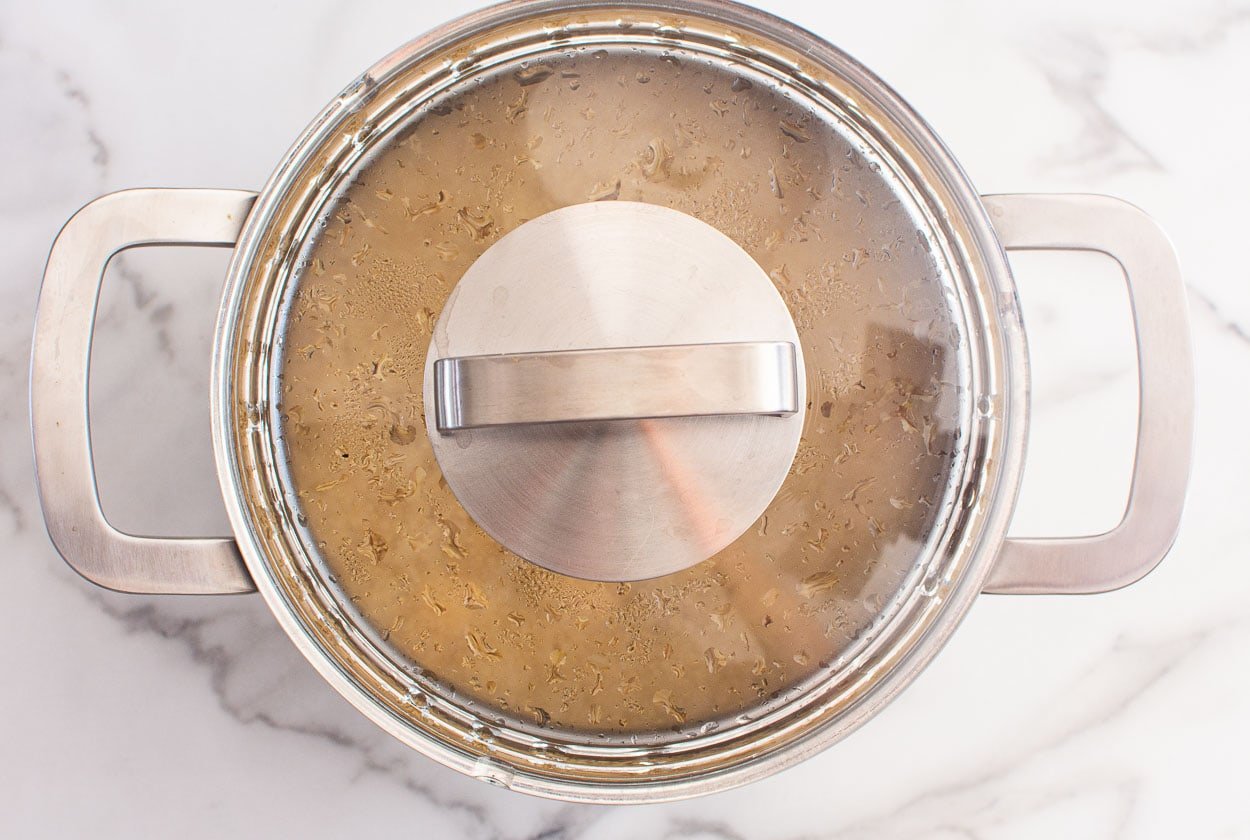 Quinoa resting in pot with a lid.