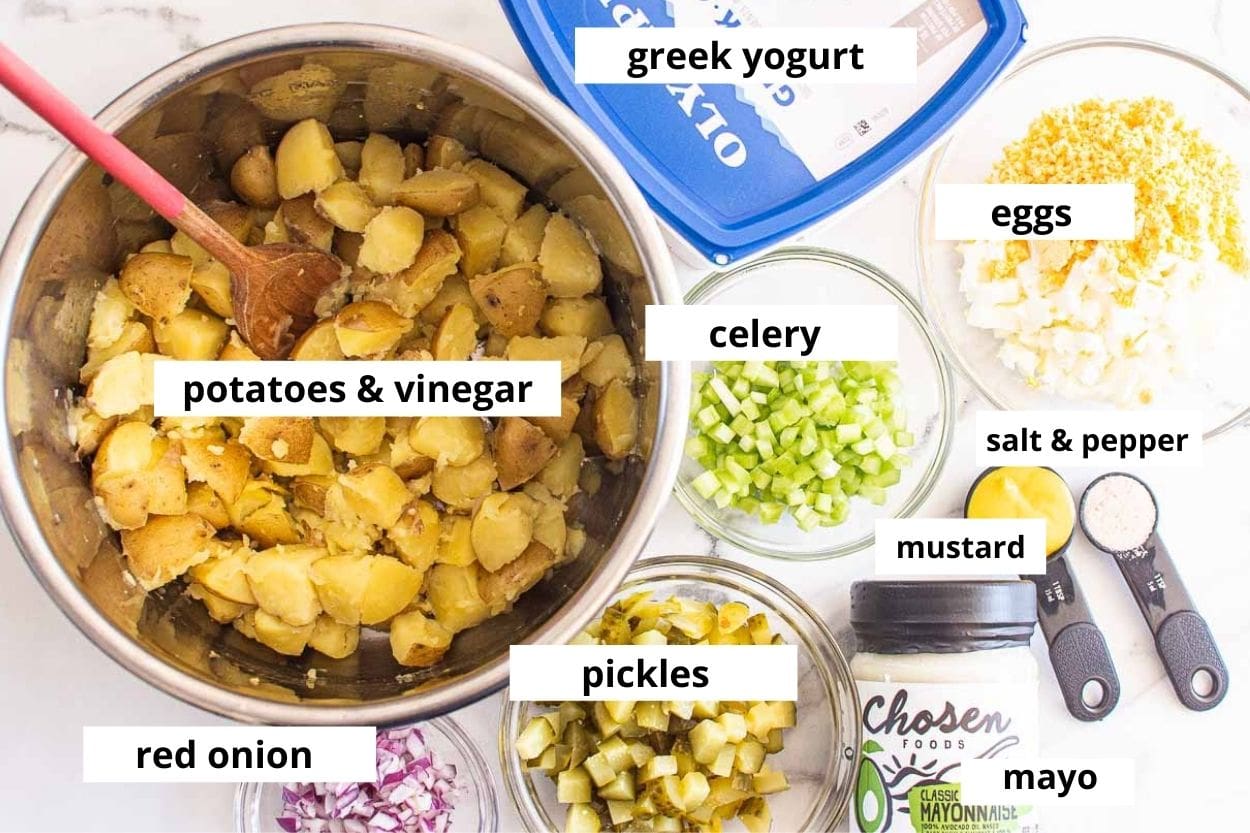Potatoes with vinegar in the pot, pickles, celery, eggs, red onion, mayo, mustard, yogurt, salt and pepper.