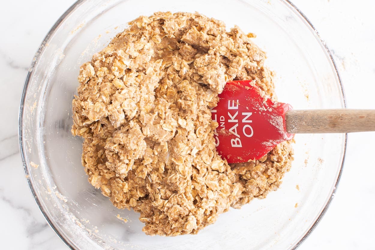 Blueberry oatmeal bars crossed dough mixed with spatula in a bowl.