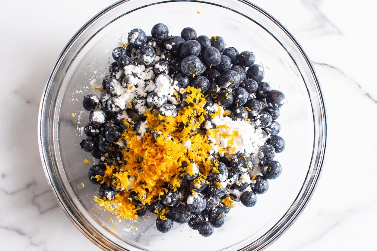 Blueberries, orange zest and cornstarch in a bowl.