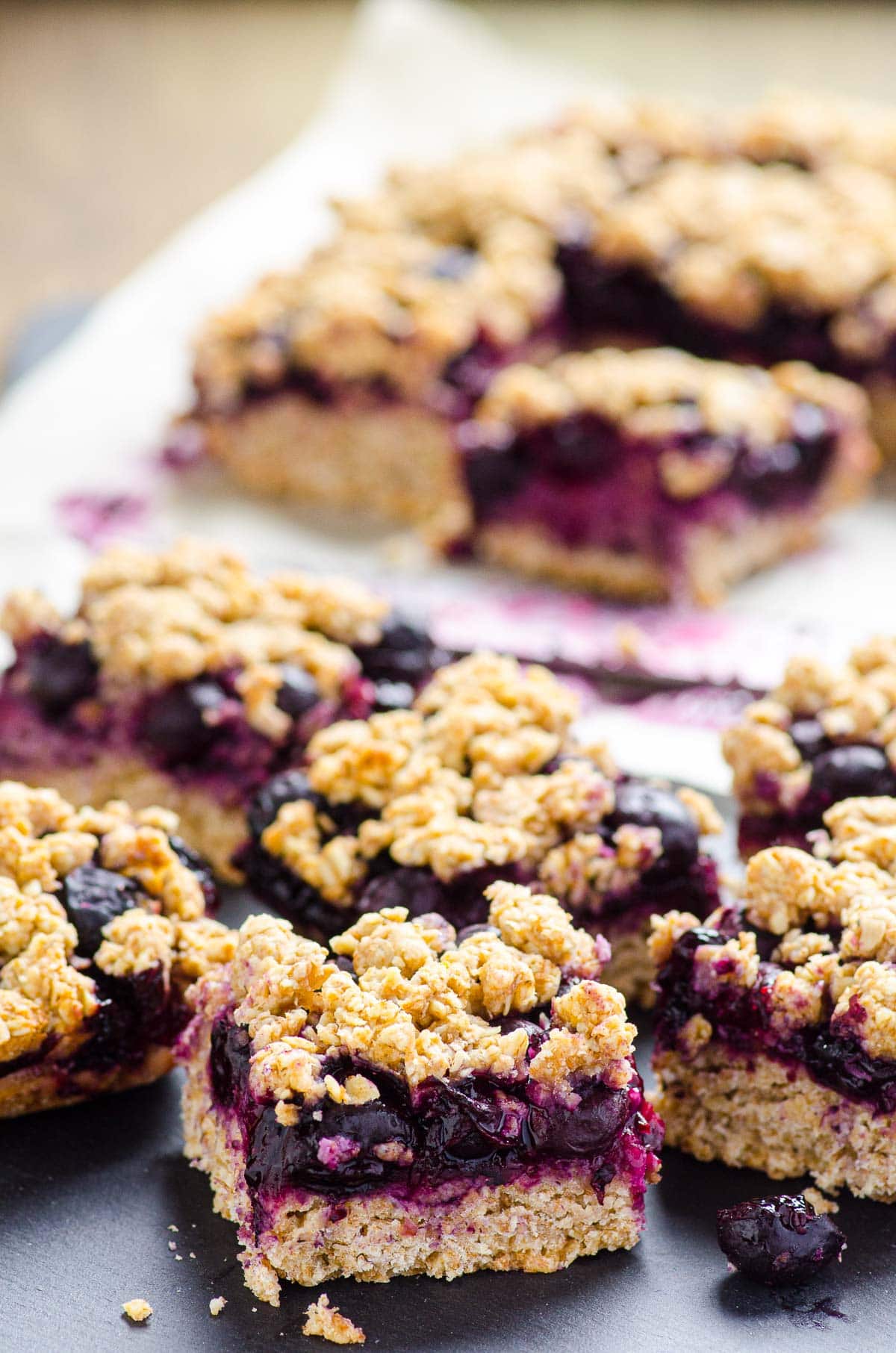 Blueberry oatmeal bars cut into squares and served on black platter.