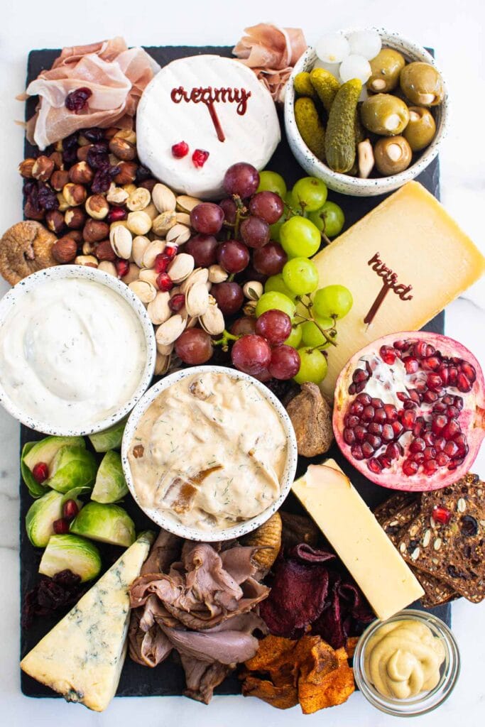 christmas charcuterie board with meats cheese fruit pickled veggies and nuts