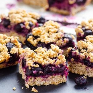 Blueberry oatmeal bars cut into squares and served on black platter.
