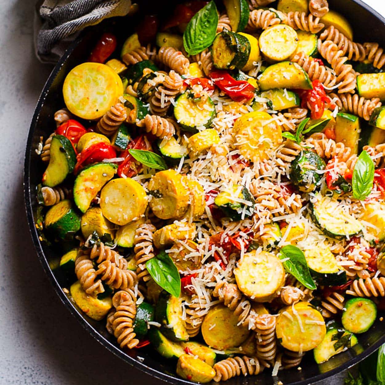 pasta with zucchini and tomatoes in skillet