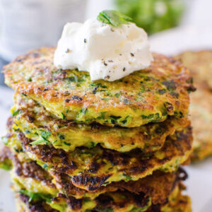 stacked zucchini fritters with a dollop of greek yogurt