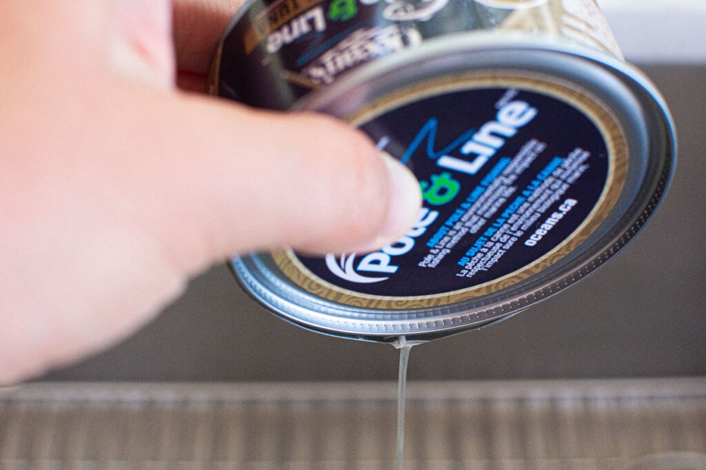 draining open can of tuna