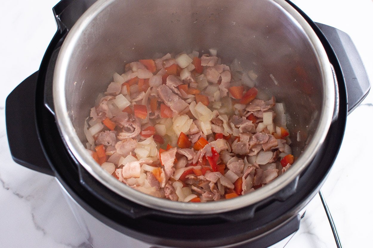 Chopped bacon, bell pepper and onion sauteing in Instant Pot.