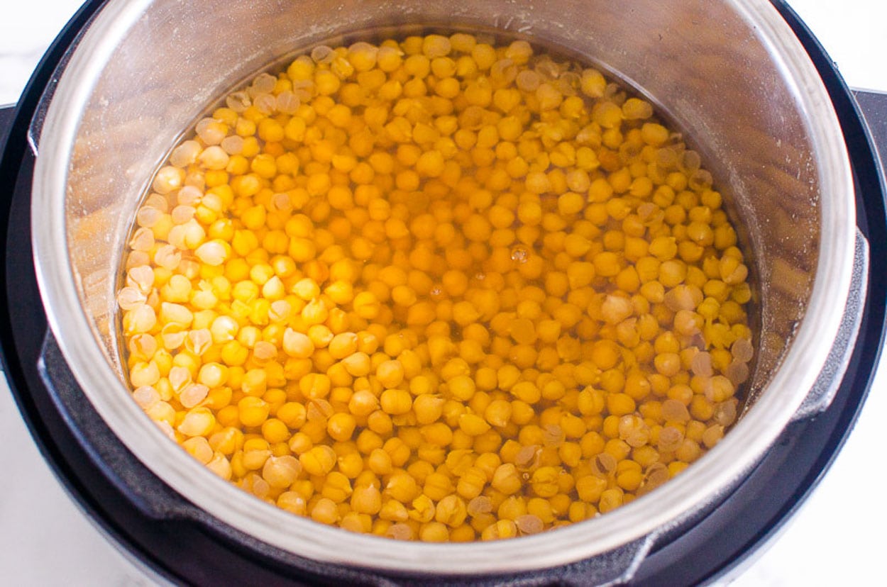 Cooked chickpeas covered in broth in Instant Pot.