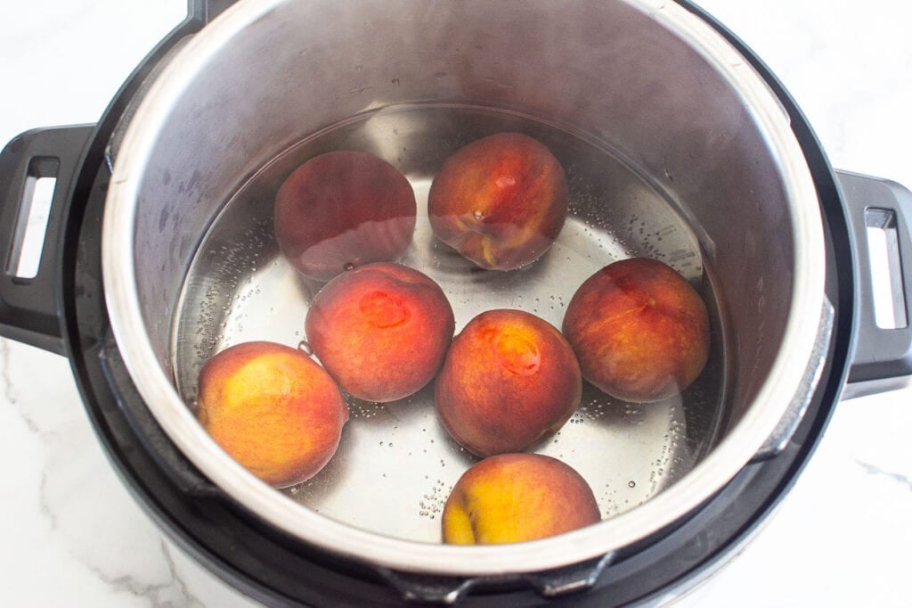 Peach in water inside Instant Pot.