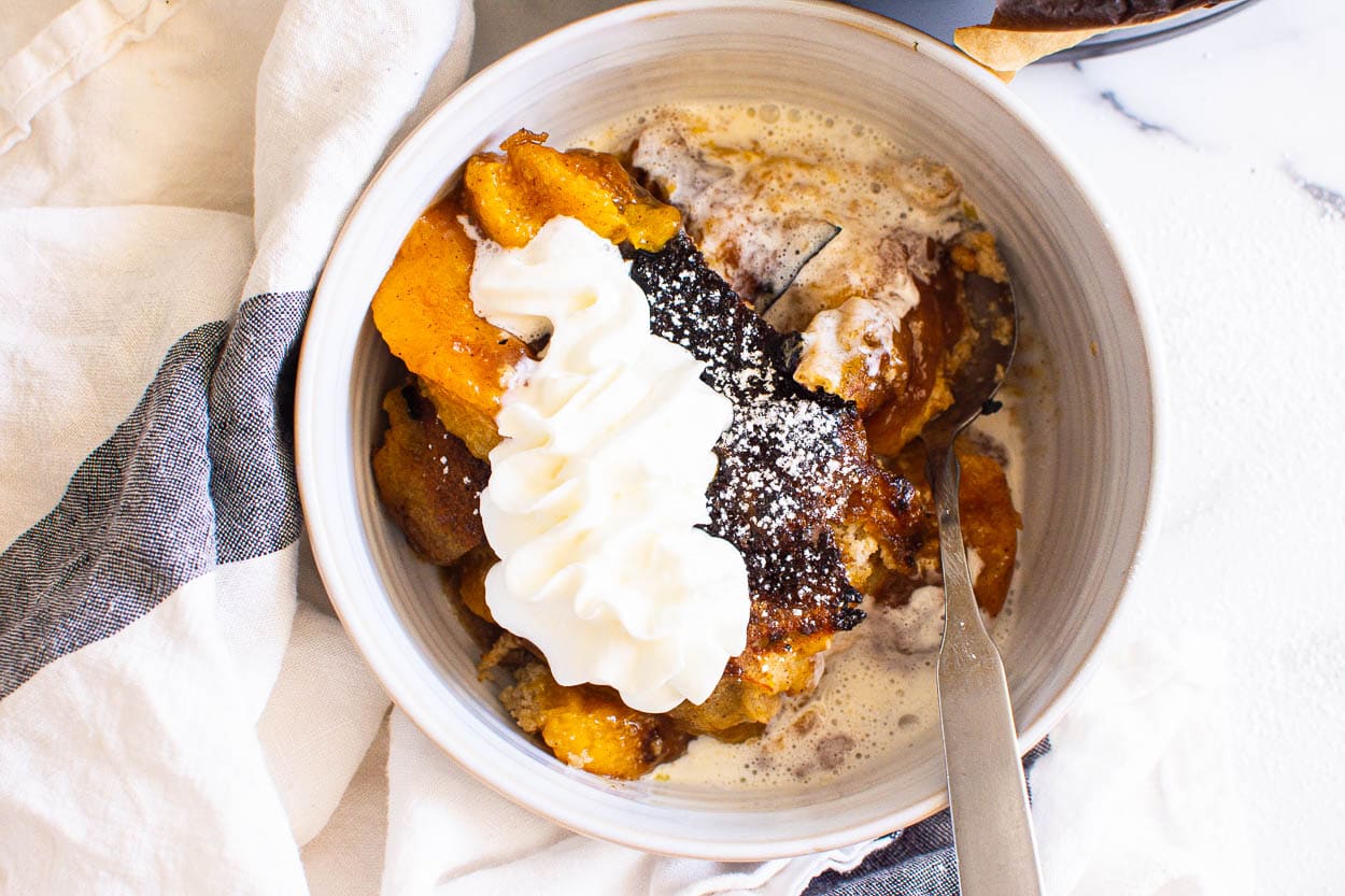 Fruit cobbler made in instant pot with whipped cream and spoon.