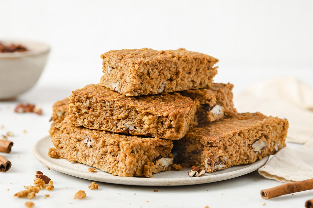 Pumpkin protein bars stacked on a plate.