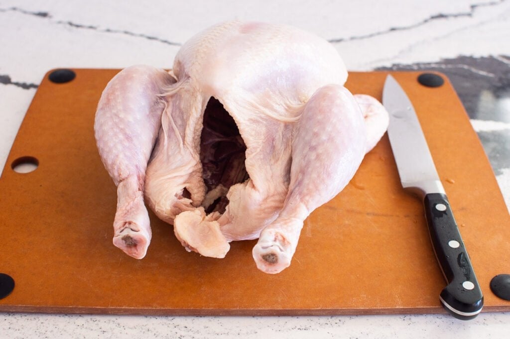 whole chicken on cutting board to cut