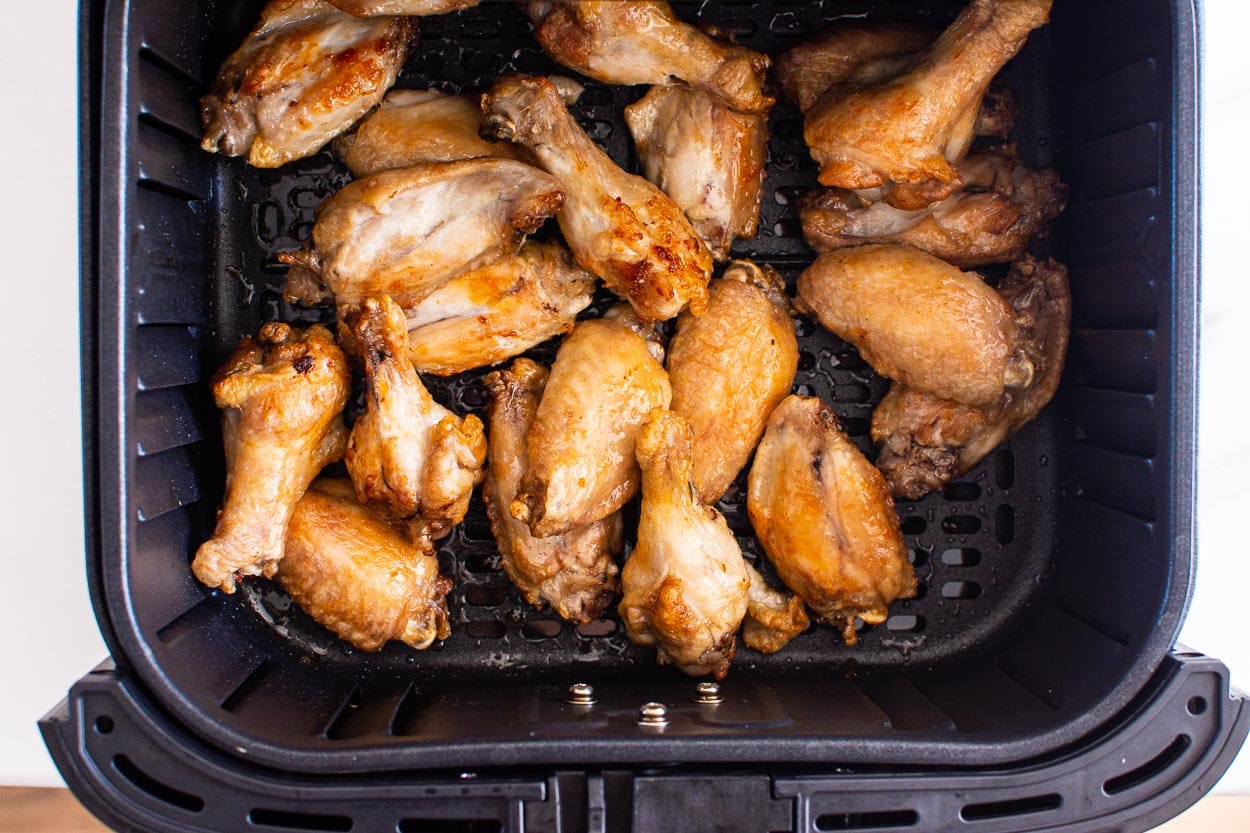 Air fried chicken wings in a basket of air fryer.