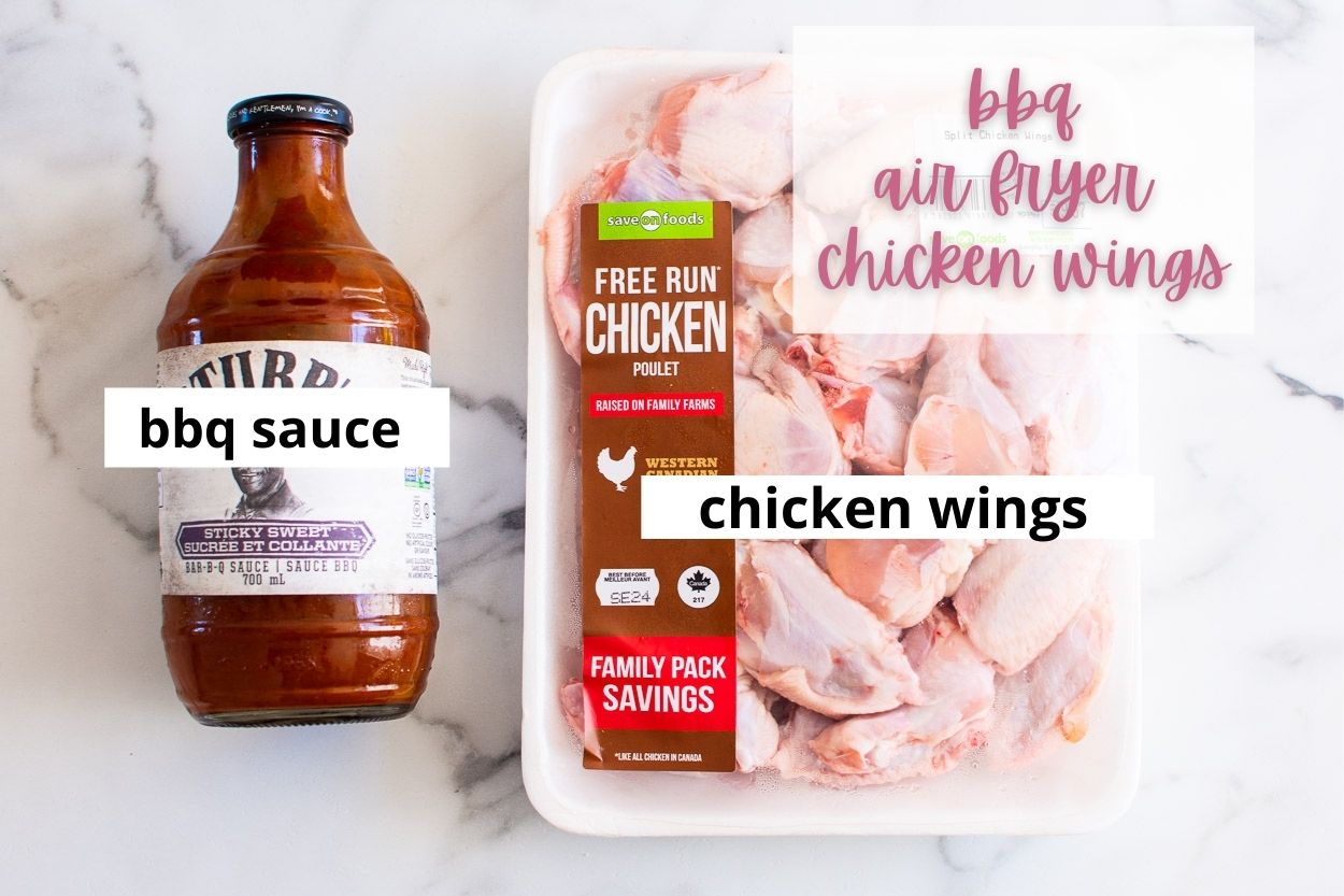 Bbq sauce in a bottle and raw chicken wings in packaging.