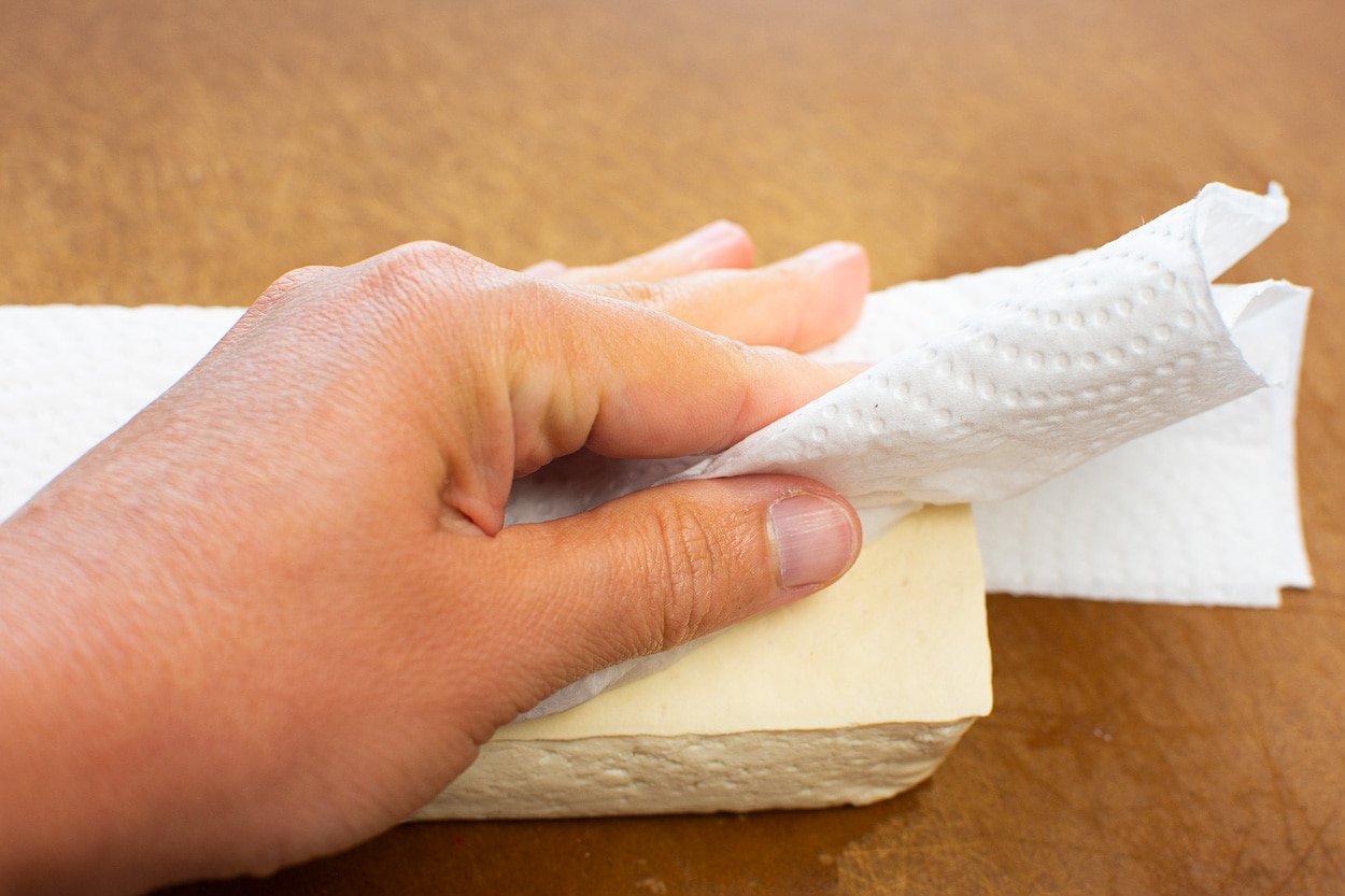 Pat drying tofu block with paper towel.