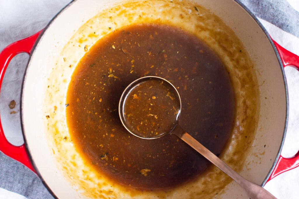 turkey gravy in a stock pot with ladle
