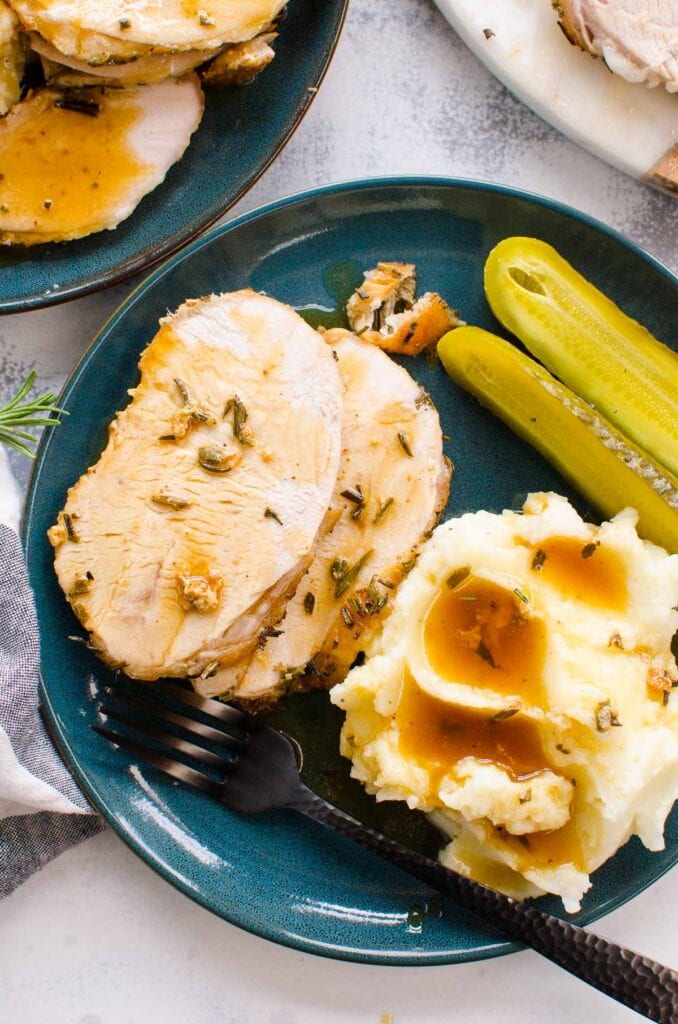roast turkey breast recipe plated with mashed potatoes and gravy and pickles 