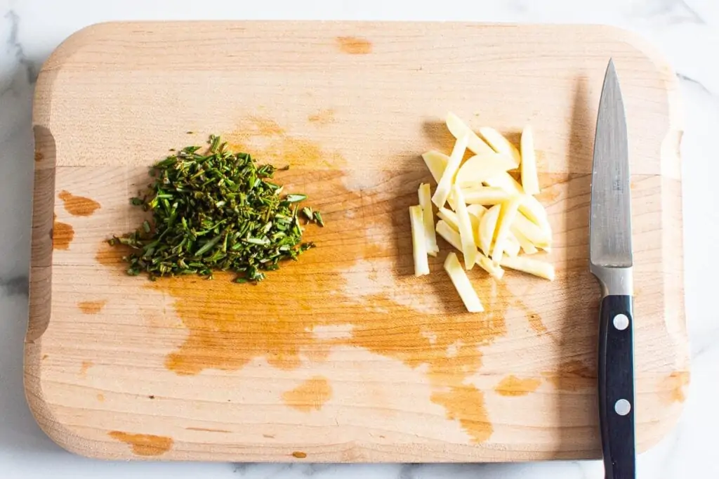 garlic and rosemary chopped on a cutting board
