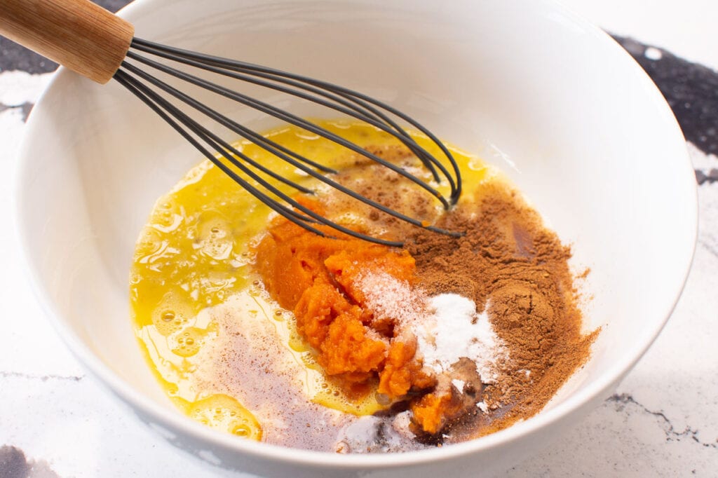 whisking pumpkin and pumpkin spice with eggs and baking staples