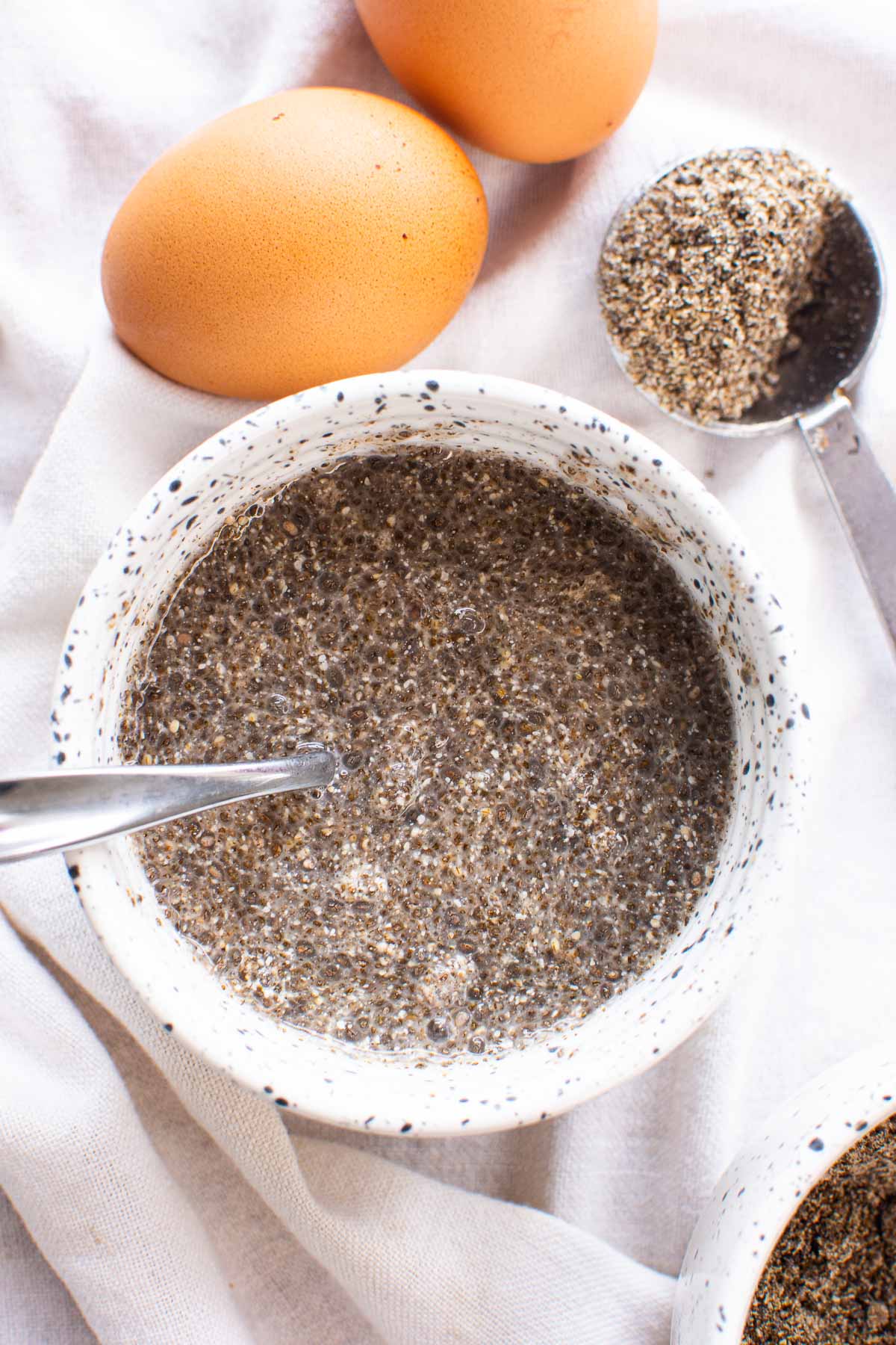 Chia egg with a spoon in white bowl.