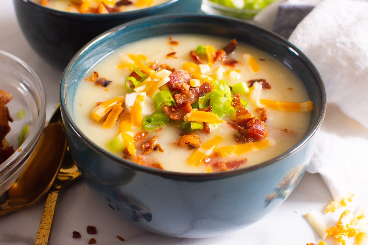 Instant Pot potato soup garnished with bacon, cheese and green onion.