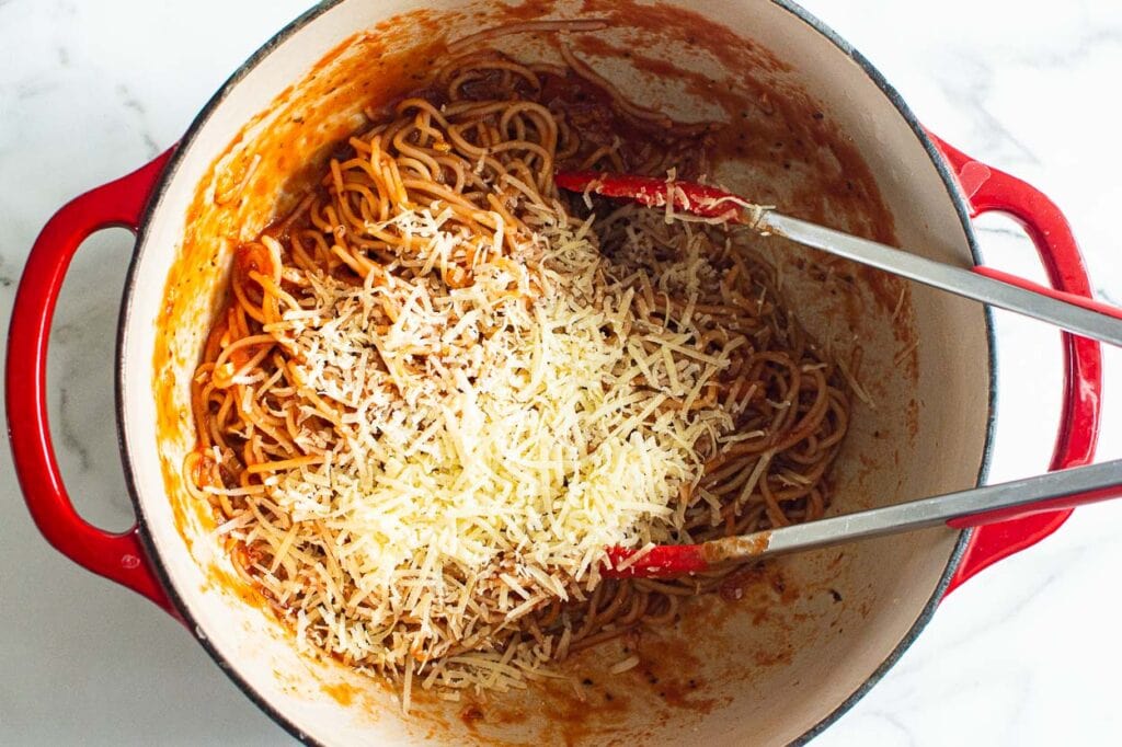 adding a generous amount of parmesan to easy spaghetti recipe