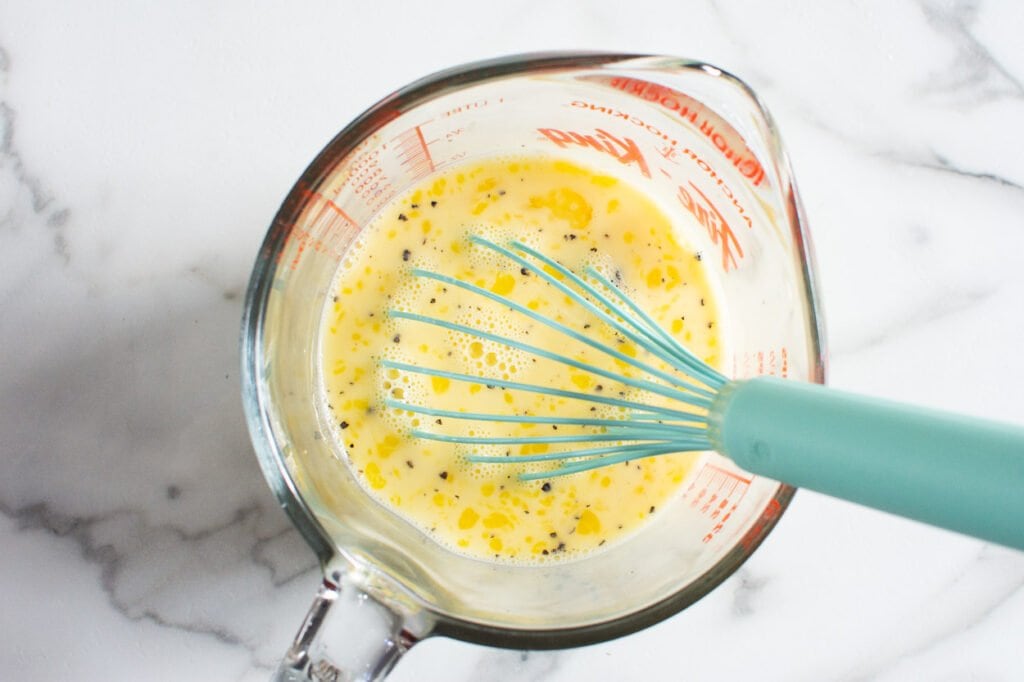 Whisked eggs, milk, salt and pepper in large measuring cup.