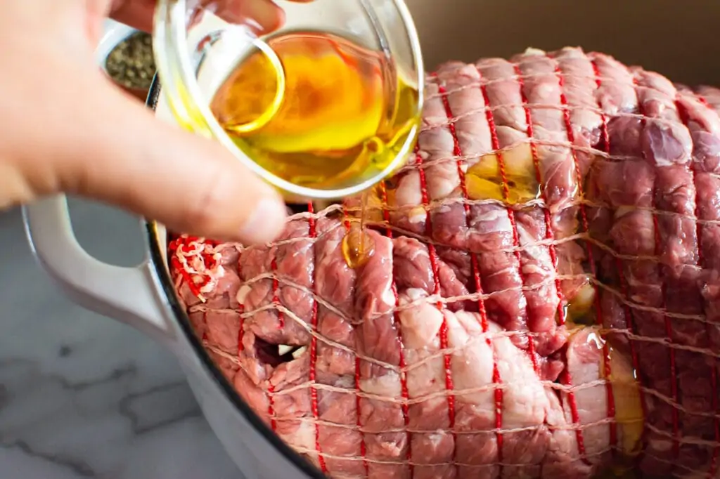 pouring oil on lamb roast