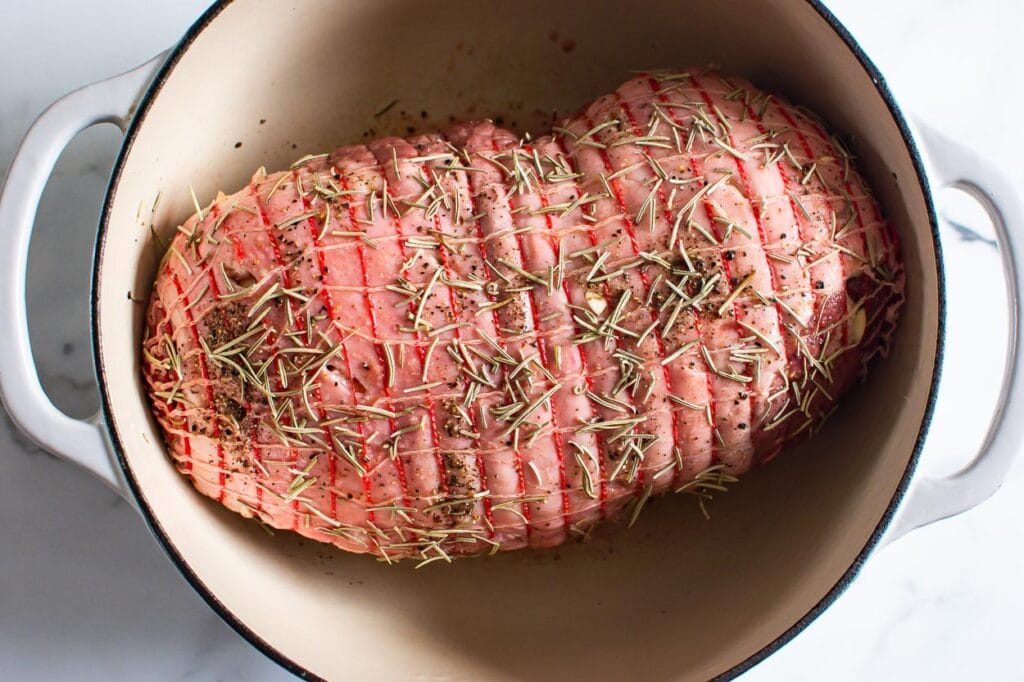 seasoned boneless leg of lamb roast in a pan