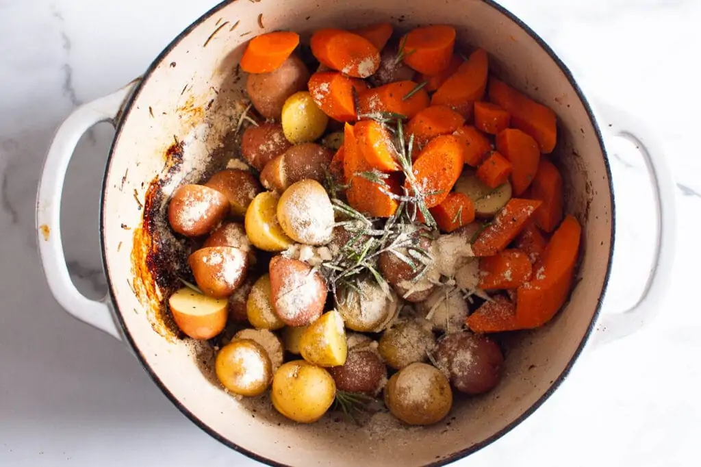 seasoned potatoes and carrots in dutch oven