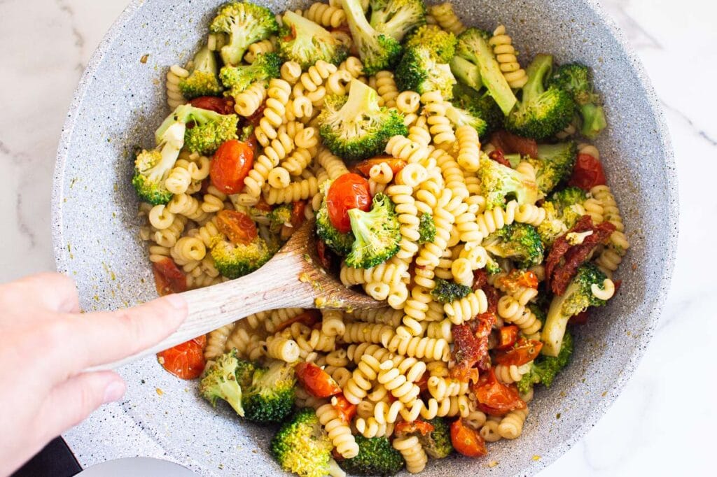 Stirring pasta and vegetable mixture.