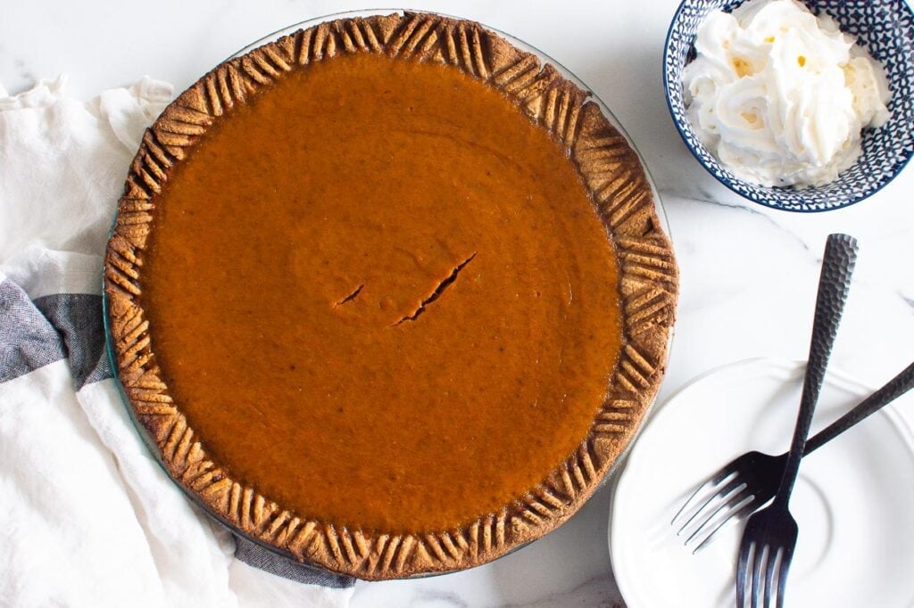 healthy pumpkin pie recipe ready to serve with forks and whipped cream