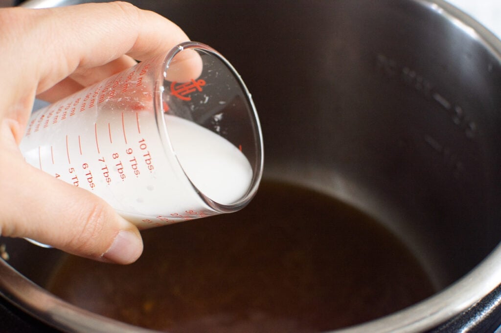 pouring cornstarch into pressure cooker pot