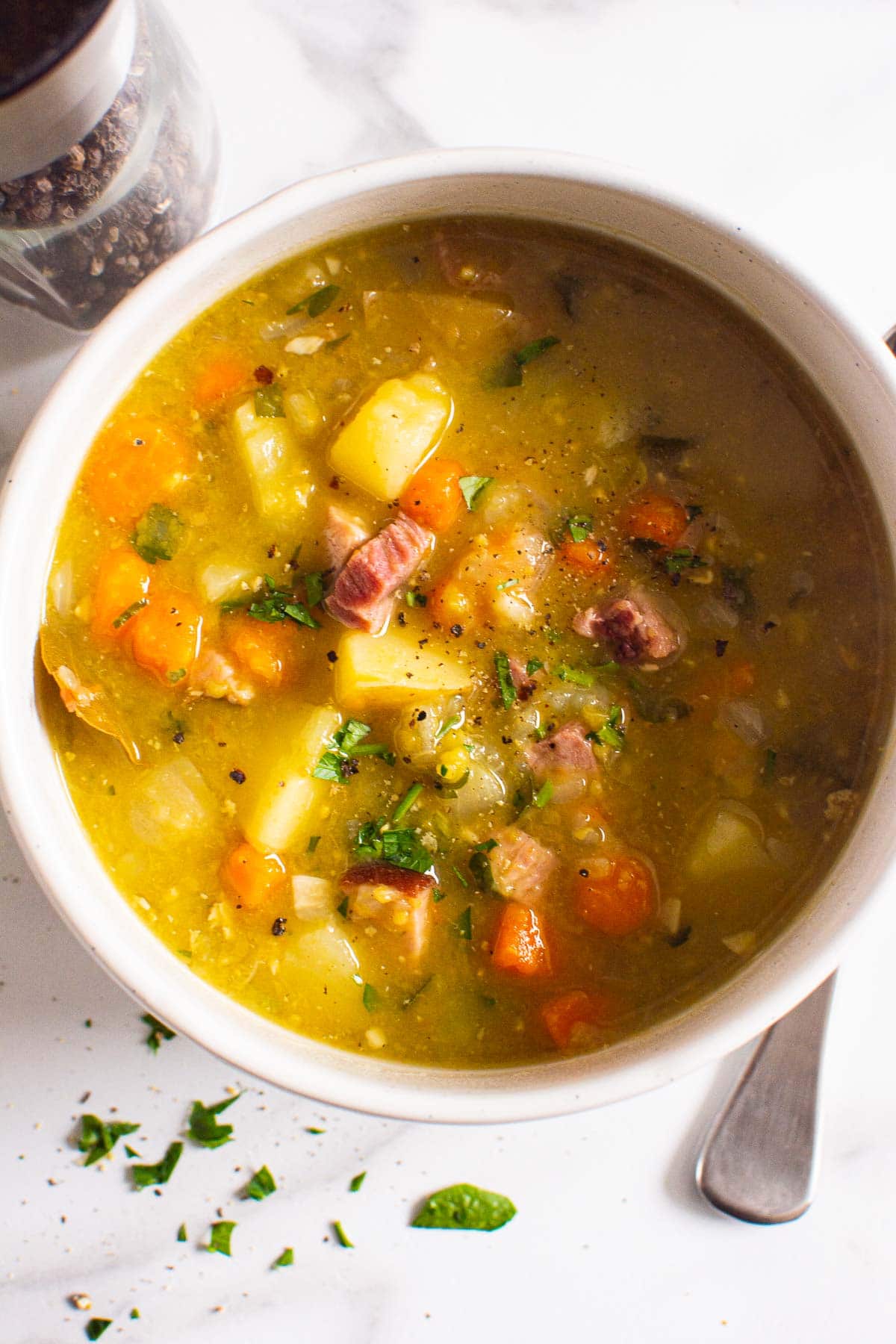 Instant Pot split pea soup with ham, vegetables and parsley served in a bowl.