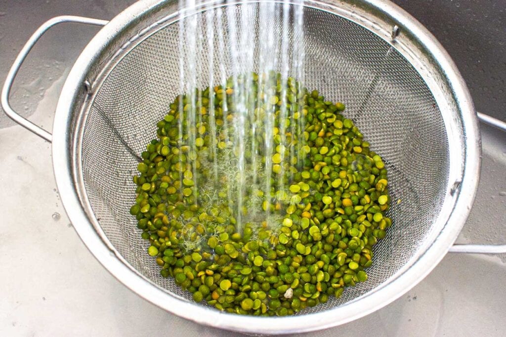 green split peas being rinsed