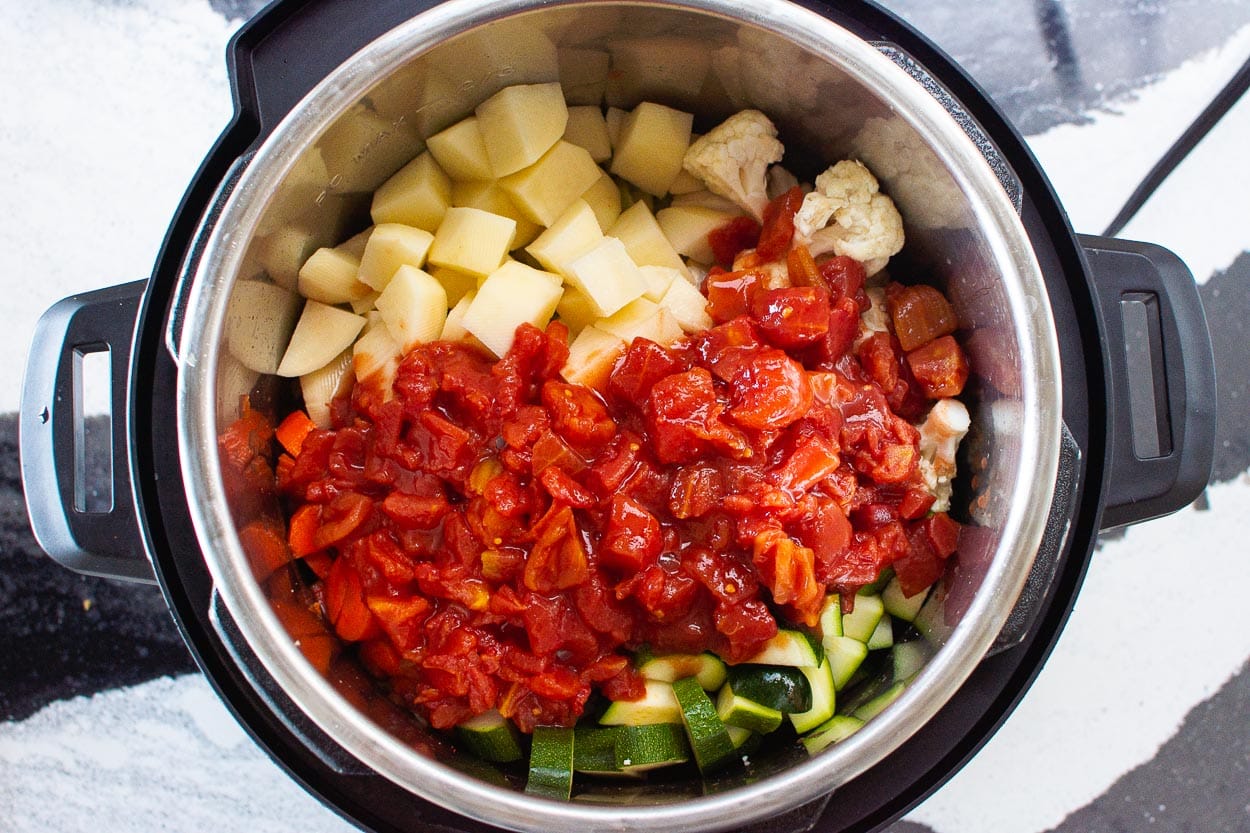 Zucchini, potatoes, diced tomatoes and cauliflower in Instant Pot.