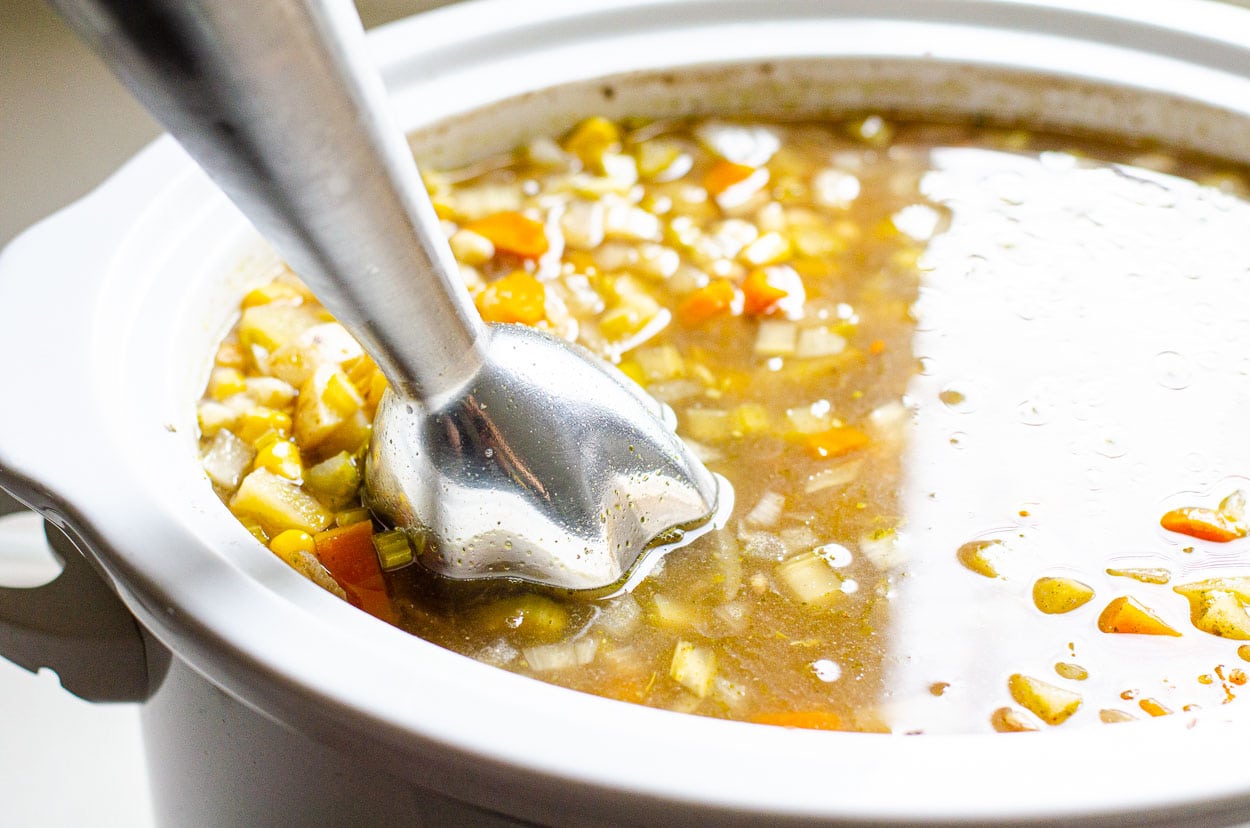 Blending soup with immersion blender in slow cooker.