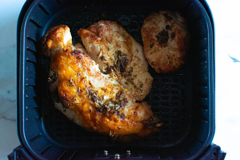 Air fried turkey breast in a basket of air fryer.