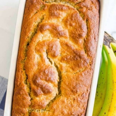 almond flour banana bread in a pan with fresh bananas