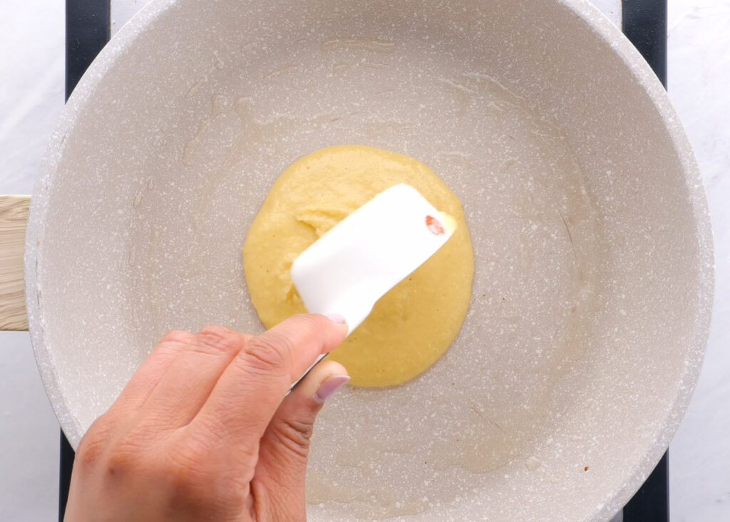 pouring batter of almond flour pancakes into skillet