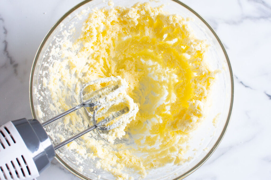 Creaming butter and sugar with electric mixer.