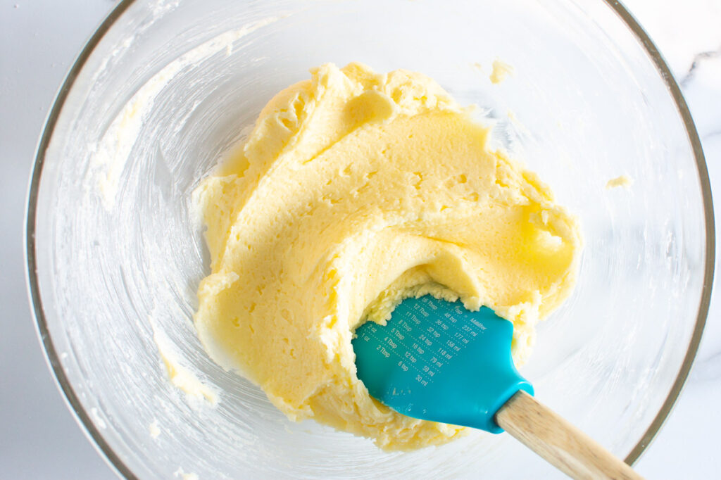 Stirring creamed butter and sugar with spatula. 